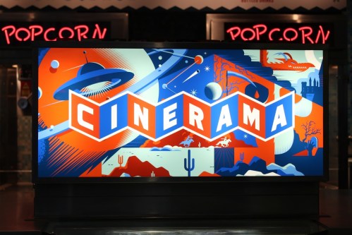Colorful Cinerama sign with space and landscape graphics, set against a backdrop of popcorn signage.