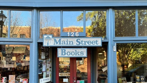 Sign for "Main Street Books" on a storefront with large windows and a welcoming entrance.