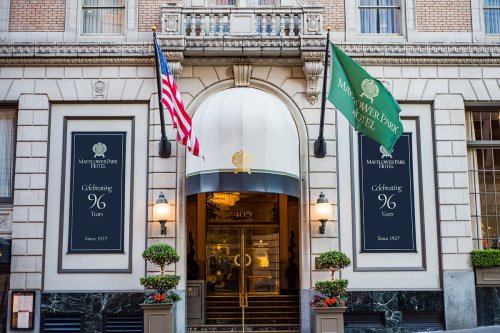 Entrance of the Mayflower Park Hotel, featuring flags and banners celebrating 96 years since 1927.