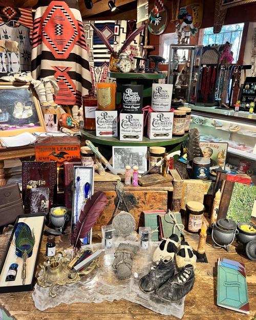 A vibrant display of eclectic items, including vintage bottles, books, and decorative objects, in a cozy shop setting.