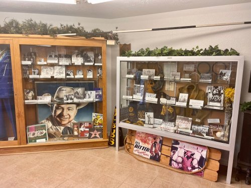 Display cases filled with historical photos, memorabilia, and artifacts in a museum setting.