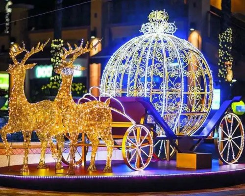 A festive display featuring illuminated reindeer and a sparkling carriage, surrounded by colorful lights.
