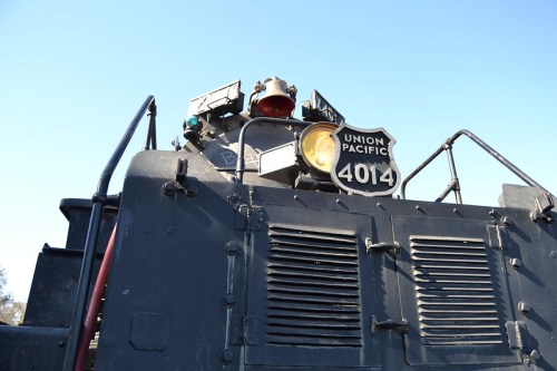 Close-up of a Union Pacific locomotive's front, featuring the number 4014 and various lights against a clear blue sky.
