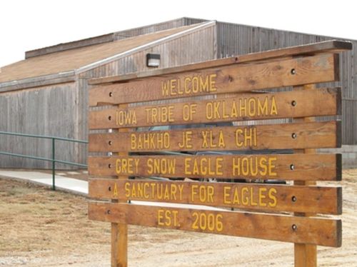 Wooden sign welcoming visitors to the Iowa Tribe of Oklahoma's Grey Snow Eagle House, established in 2006.