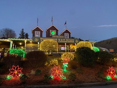 A festive building decorated with colorful lights and holiday decorations, set against a twilight sky.