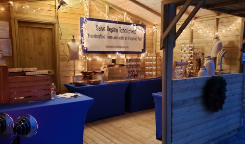 A cozy market stall with wooden decor, showcasing handcrafted items and twinkling lights.