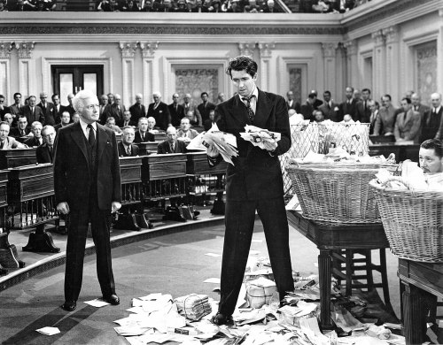A dramatic scene in a Senate chamber with a man standing amidst scattered papers, addressing a crowd of onlookers.