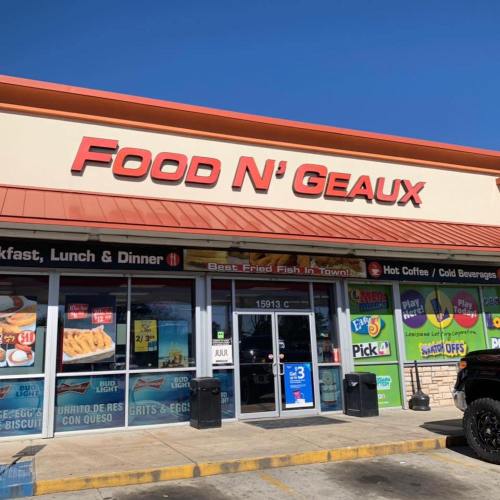 Sign for "Food N' Geaux" restaurant featuring breakfast, lunch, and dinner options, with a bright blue sky above.