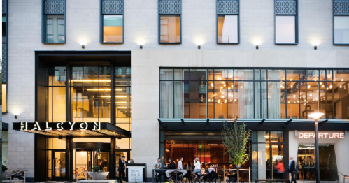 Exterior view of the Halcyon hotel, featuring modern architecture and outdoor seating with guests dining.