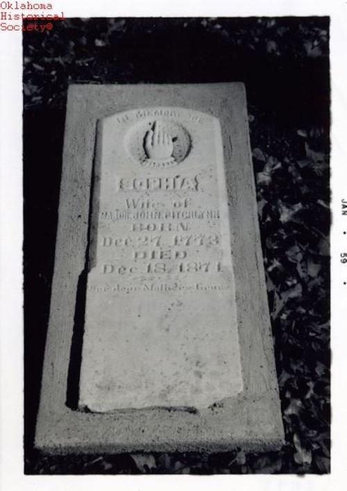 Black and white photo of a gravestone inscribed with the name "Eugenia," dates of birth and death, and a hand symbol.