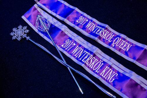 Two sashes reading "2017 Wintersköl Queen" and "2017 Wintersköl King," alongside a snowflake wand and a silver staff.