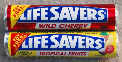 Two rolls of Life Savers candy: one labeled "Wild Cherry" and the other "Tropical Fruits," both marked as fat-free.