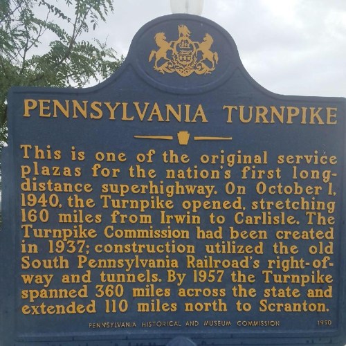 Sign detailing the history of the Pennsylvania Turnpike, highlighting its opening date and original service plazas.