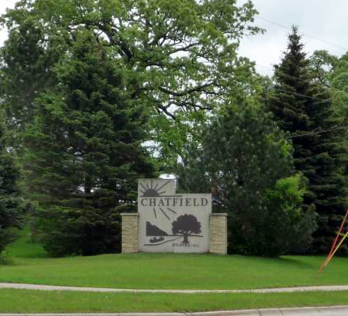 Sign for Chatfield, surrounded by trees, with the year founded (1853) displayed prominently.