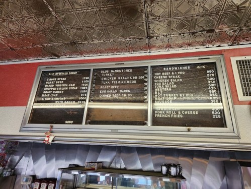 Menu board displaying daily specials and sandwich options, including prices for various items like turkey and roast beef.