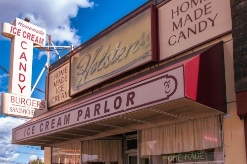 A vintage ice cream parlor sign featuring "Homemade Ice Cream" and "Candy" with a classic storefront design.