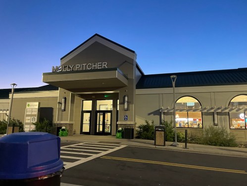 Exterior of the Molly Pitcher building at dusk, featuring large windows and a welcoming entrance.