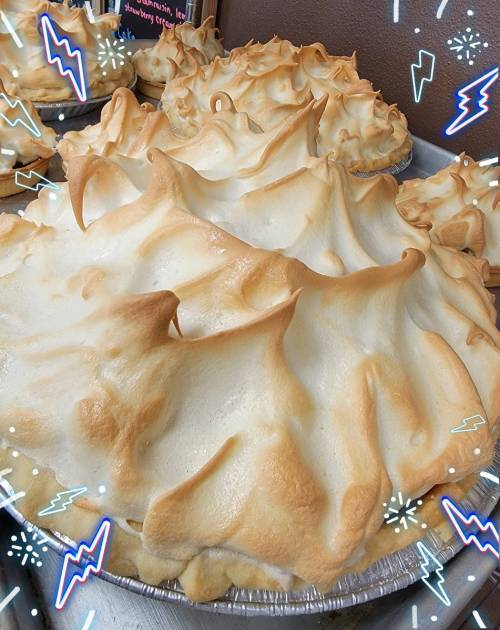 A close-up of a beautifully baked meringue pie with a golden, textured topping.