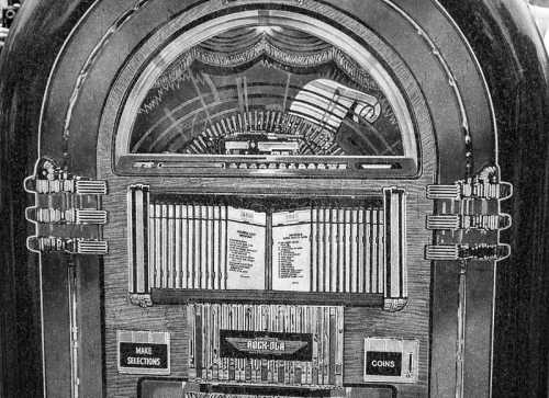 A vintage jukebox with a decorative front, featuring buttons for selections and a coin slot.