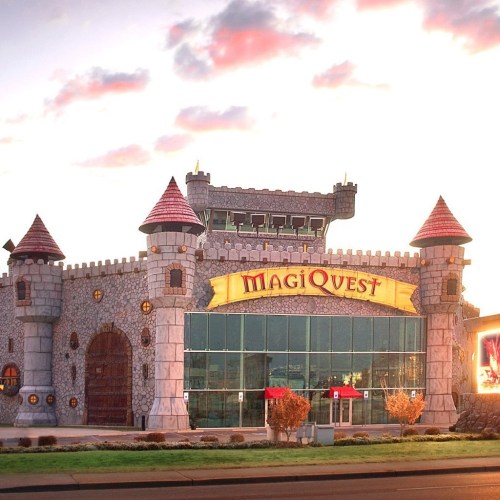 A whimsical castle-themed building with turrets, featuring the sign "MagiQuest" in bright colors.