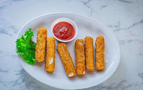 A plate of golden-brown breaded sticks with a side of marinara sauce and a lettuce leaf.