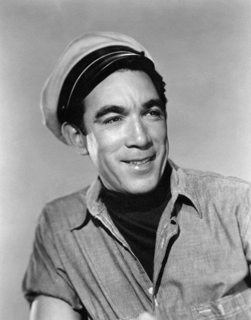 A smiling man in a sailor's hat and casual shirt, looking confidently at the camera.