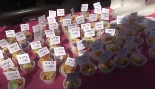 Colorful dessert cups arranged on a table, each topped with a small "VOTE" sign.