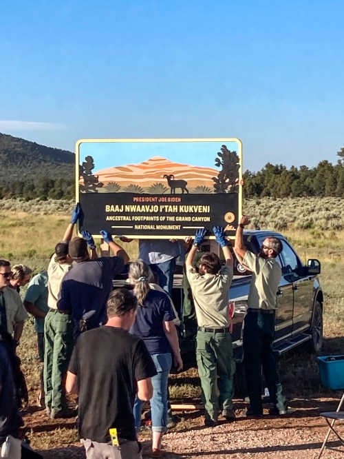 Group of people installing a sign for Baaj Nwaavjo I'tah Kukveni National Monument near the Grand Canyon.