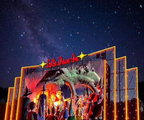A vibrant drive-in theater illuminated at night, featuring animated characters against a starry sky backdrop.