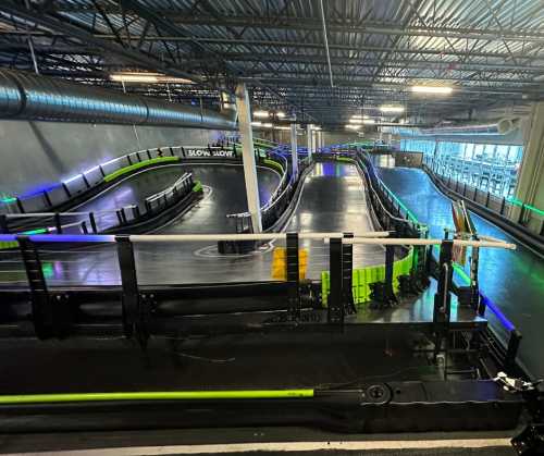 A view of an indoor go-kart track with winding paths and colorful lighting.