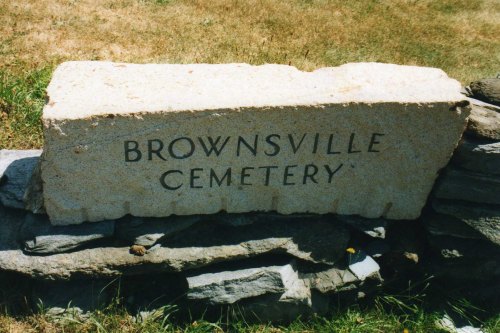 A stone sign reading "BROWNSVILLE CEMETERY" on a grassy background.