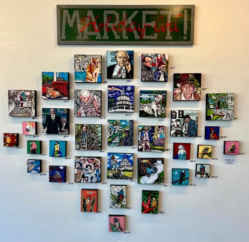 A vibrant art display featuring various small paintings on a wall, labeled with numbers, under a "Market Art" sign.