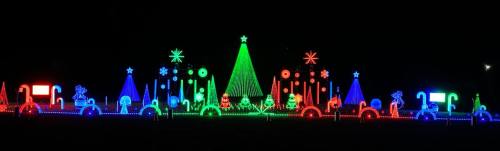 Colorful Christmas light display featuring trees, stars, and festive decorations in red, green, and blue against a dark background.