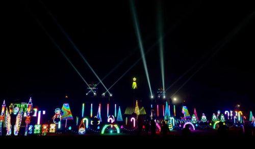 A vibrant display of colorful lights and decorations at night, featuring various shapes and patterns.