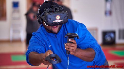 A person wearing a VR headset and controllers, smiling while engaging in a virtual reality experience.