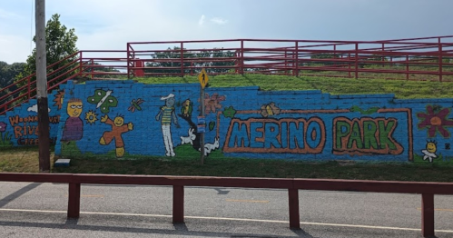Colorful mural at Merino Park featuring cartoon characters and flowers on a blue background.
