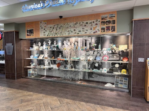 Display case featuring historical artifacts and memorabilia, labeled "America's Dream," with various plates and photos.
