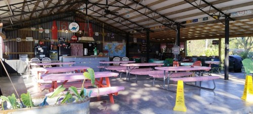 A rustic indoor dining area with checkered tables, a map on the wall, and a casual, welcoming atmosphere.