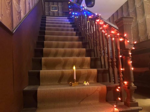 A staircase decorated with colorful lights and a candle, creating a warm, inviting atmosphere.