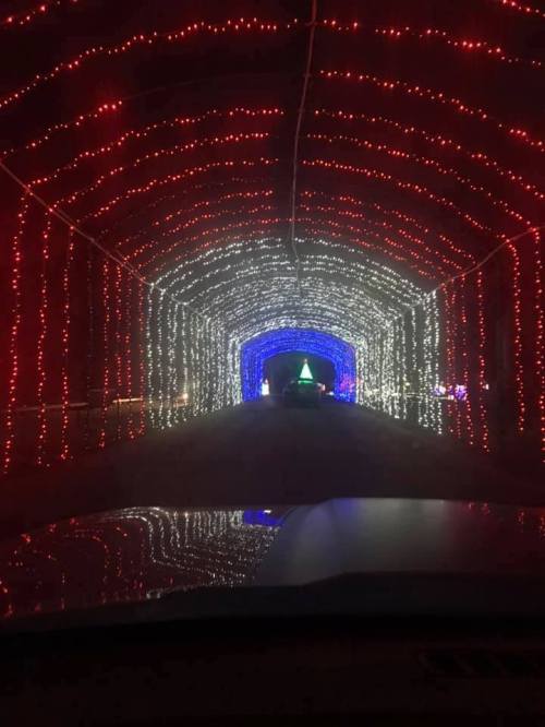 A colorful tunnel of red, white, and blue lights leading to a festive display at the end.
