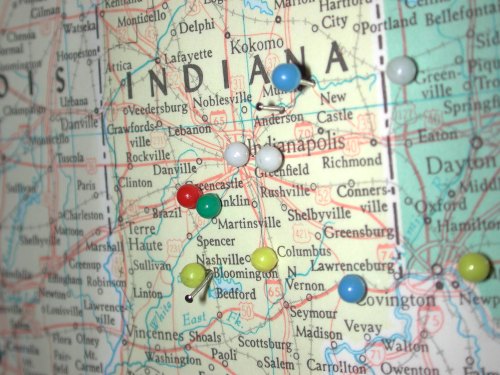 A close-up of a map of Indiana with various colored pushpins marking different locations.