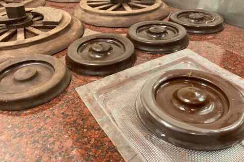 A collection of round chocolate molds on a granite surface, showcasing various sizes and designs.