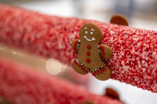 A festive gingerbread man decoration on a red, sparkly surface, adding a cheerful holiday touch.