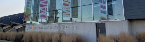 Exterior of the Community Arts & Recreation Center, featuring large banners and modern architecture.