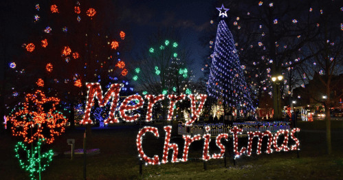 Colorful Christmas lights display featuring a large "Merry Christmas" sign and a decorated tree at night.