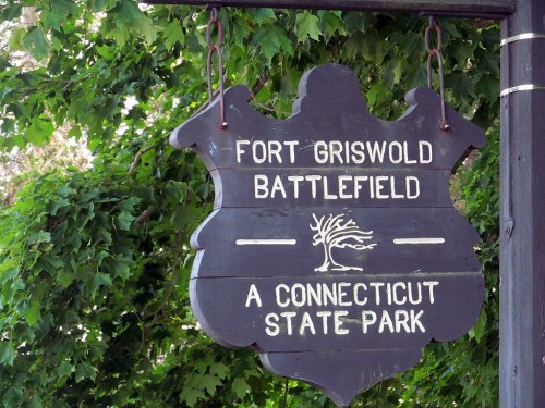 Sign for Fort Griswold Battlefield, a Connecticut State Park, surrounded by green foliage.
