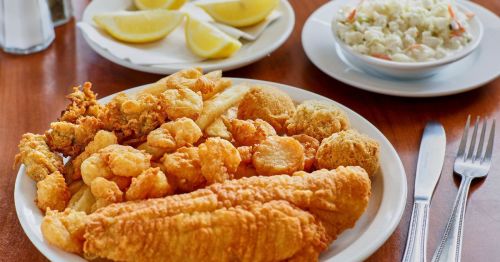 Fried catfish platter with hushpuppies, shrimp, coleslaw, and lemon wedges