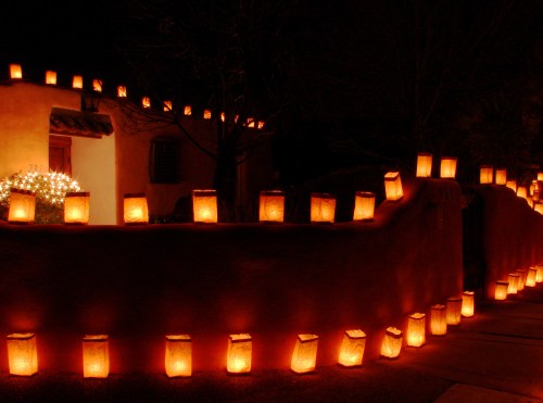 A warm, glowing display of lanterns lining a pathway and walls of a house at night, creating a festive atmosphere.