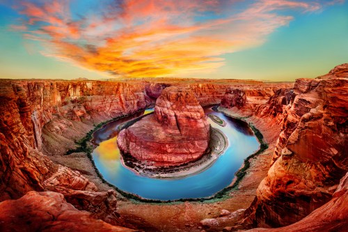 A stunning sunset over Horseshoe Bend, showcasing vibrant colors reflecting in the winding river and surrounding cliffs.