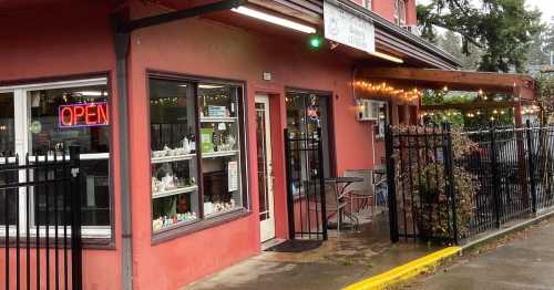 Exterior of Mehri's Cafe & Bakery, featuring a pink building, open sign, and a sign for holiday pies and desserts.